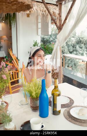 Belle femme asiatique portant la tête assise et se relaxant sur la table à manger avec la boisson décorer dans le café le week-end Banque D'Images