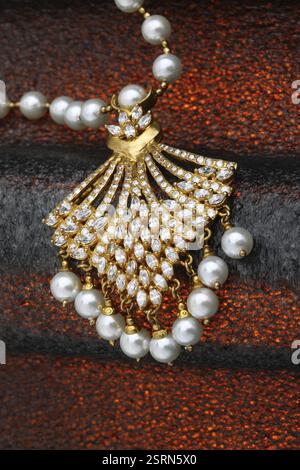 Collier bijoux en or avec des diamants et des perles rouges sur fond noir Banque D'Images