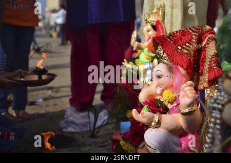 Les dévots effectuer pooja avant d'effectuer une idole du dieu Hindou à la tête d'éléphant Ganesh pour l'immersion dans la mer d'Oman Mumbai Banque D'Images