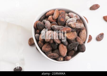 Bol de grains de cacao sur fond blanc Banque D'Images