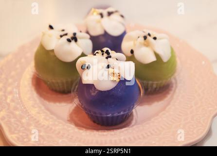 Kanom Pra Pai, un dessert thaïlandais traditionnel à base de pâte de farine de riz gluante de couleur végétale farcie de pâte de haricots mungo garnie de lait de coco Banque D'Images