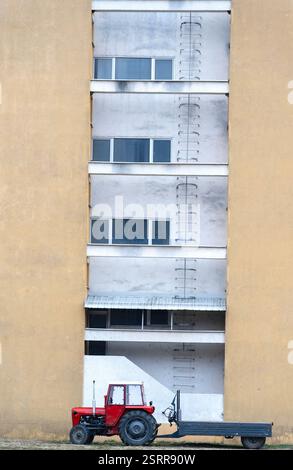 Châssis Power – tracteur IMT rouge avec remorque en milieu urbain Banque D'Images