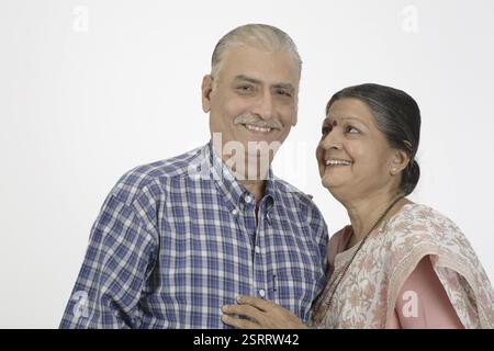 Vieux couple souriant, dame gardait sa main droite sur l'épaule et l'autre sur la poitrine regardant l'homme MR # 703A et 703B. Banque D'Images