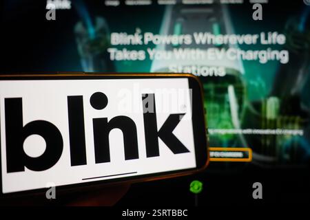 Roosendaal, pays-Bas - 16 février 2025:Un téléphone portable affichant le logo de Blink Charging, avec le site Web de la société en arrière-plan. Banque D'Images