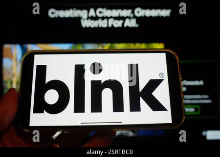 Roosendaal, pays-Bas - 16 février 2025:Un téléphone portable affichant le logo de Blink Charging, avec le site Web de la société en arrière-plan. Banque D'Images