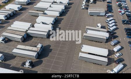 Vue aérienne d'un grand parking rempli de semi-remorques et camions stationnés. Banque D'Images