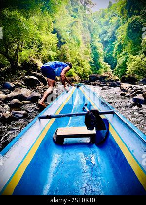 batelier tirant son bateau en amont de la rivière Banque D'Images