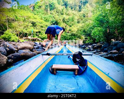batelier tirant son bateau en amont de la rivière Banque D'Images