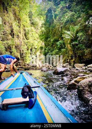 batelier tirant son bateau en amont de la rivière Banque D'Images