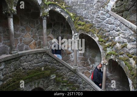 Un groupe diversifié de personnes pose décontractée sur un escalier, créant une scène franche sur fond de ville dynamique. Sintra, Portugal. Banque D'Images