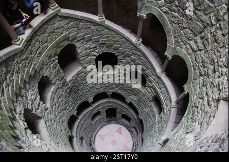 Un escalier en colimaçon en pierre sinueux plonge dans un puits ombragé. Une merveille architecturale fascinante à Sintra, au Portugal. Une descente dans une Re souterraine Banque D'Images