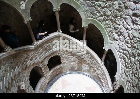 Sintra, Portugal. Un escalier en colimaçon en pierre descend dans l'obscurité, menant à un mystérieux puits orné d'une architecture symbolique. Cette descente évoque Banque D'Images