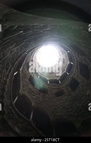 Sintra, Portugal. Une pierre fascinante plonge dans les profondeurs, son escalier en colimaçon complexe disparaissant dans l'obscurité. Cette stru énigmatique Banque D'Images