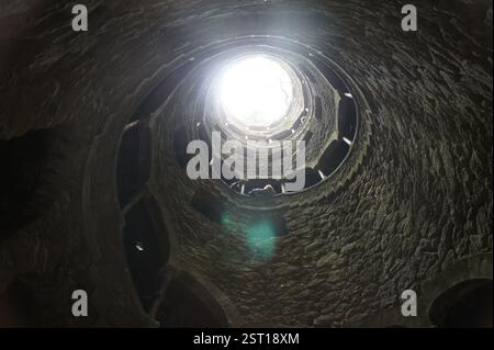Sintra, Portugal : un fascinant escalier en colimaçon plonge dans les profondeurs, évoquant un voyage symbolique dans le monde souterrain. Cette énigmatique descente promi Banque D'Images
