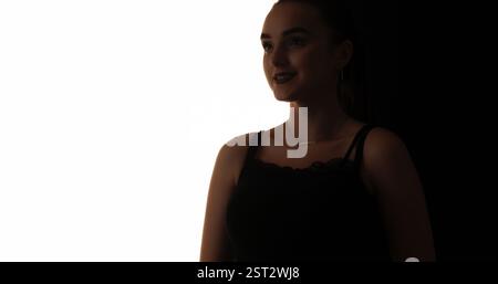 Silhouette de beauté. Visage inspiré. Contour de contraste sombre de la femme souriante joyeuse isolée sur fond d'espace de copie blanc. Banque D'Images