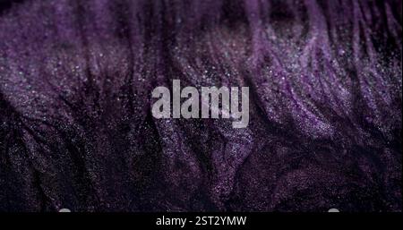 Flux d'encre. Goutte à goutte. Jet de peinture noire violette grise sur la surface du fluide d'arrière-plan chatoyant abstrait. Éclaboussures défocalisées du mélange Dark art. Banque D'Images