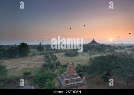 Myanmar, Bagan, montgolfières au-dessus des temples de Bagan dans la brume tôt le matin vu du temple Shwesandaw. Banque D'Images