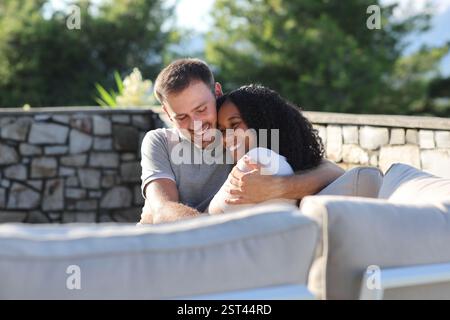Heureux couple interracial embrassant dans une terrasse une journée ensoleillée Banque D'Images