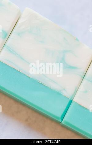 Gros plan de pains de savon faits à la main avec motif marbré sarcelle et blanc Banque D'Images