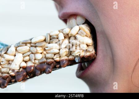 enfant fille mangeant chèvre, bouche gros plan, Banque D'Images