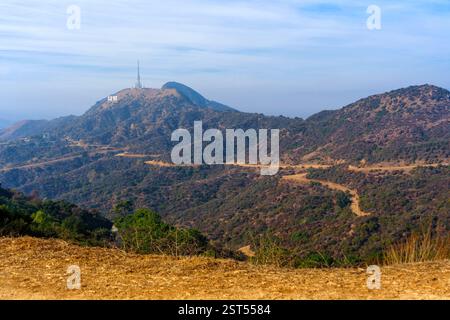 Los Angeles, Californie - 28 décembre 2024 : vue panoramique sur l'emblématique panneau Hollywood au sommet des collines, avec des sentiers de randonnée sinueux et atmosphère brumeuse Banque D'Images