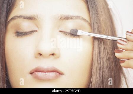 Woman applying Make-up Banque D'Images