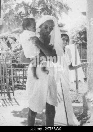 Mahatma Gandhi portant un enfant à Sevagram Ashram, mai 1940 Banque D'Images