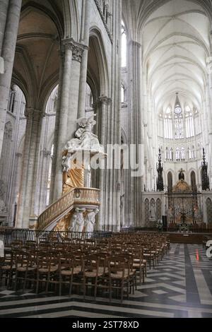La cathédrale de la nef en France, avec un plancher en labyrinthe, de grandes arches gothiques, des détails complexes de l'autel et des rangées de chaises en bois. Amiens. France 17.02.2025 Banque D'Images