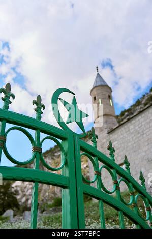 Symboles étoile et croissant de l'Islam et symbole Fleur de lis du Royaume de Bosnie, sur fond minaret flou de la mosquée Kljuc, Gacko, Bosnie et Herz Banque D'Images