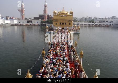 Une longue file d'attente de dévots pour adorer leur livre Saint Sri Guru Granth Sahib au Temple d'Or également connu sous le nom de Harmindar Sahib, lieu sacré de culte Banque D'Images