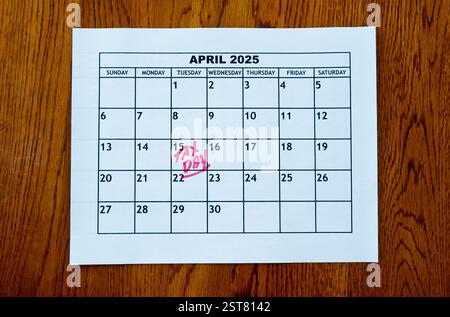 Calendrier du 2025 avril montrant US Tax Day - 15 avril - en lettres rouges manuscrites assis sur une table en bois. Banque D'Images