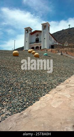 Chimbote, Pérou - 4 janvier 2023 : représentation à grande échelle de perles de Rosaire à l'extérieur de l'église de la colline de la paix avec croix sur le sommet de la colline Banque D'Images