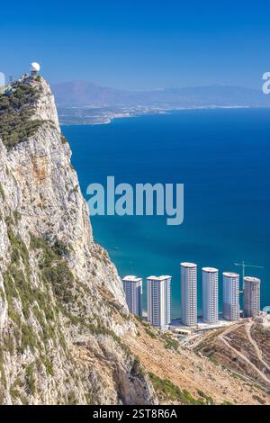 Gibraltar, territoire britannique d'outre-mer et ville sur la péninsule ibérique. Vue sur la falaise côtière avec des gratte-ciel modernes et une chaîne de montagnes lointaine. St. Banque D'Images