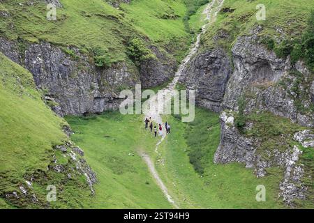 Jeunes explorant Cave Dale, une vallée karstique sèche (de calcaire carbonifère) dans le parc national de Peak District, près de Castleton, Derbyshire. Banque D'Images