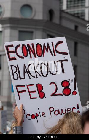 San Francisco, Calif., États-Unis, 17 février 2025. Un panneau lisant «Economic Blackout Feb. 28th! People Power ! » Est tenu haut au-dessus de la foule réunie à l'hôtel de ville de San Francisco lors d'une manifestation de la Journée des présidents de l'administration Trump. Shelly Rivoli/Alamy News. Banque D'Images