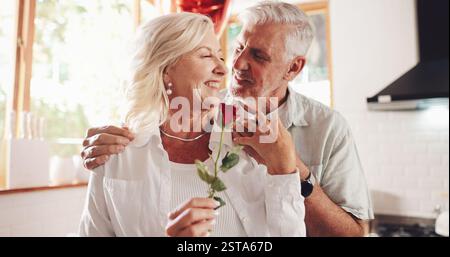 Heureux, maison et couple senior avec fleur, romance et liaison ensemble pour la Saint-Valentin. Mariage, homme mature et vieille femme avec rose, présent et Banque D'Images