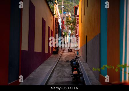 Maisons colorées dans la ville de la Guaira près de Caracas, la capitale du Venezuela. Une moto dans une rue étroite. Banque D'Images