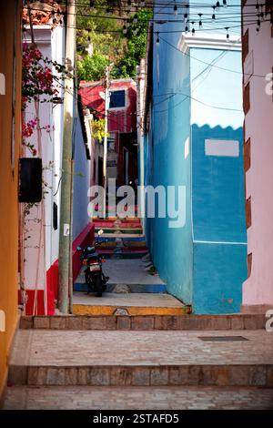 Rue étroite colorée dans la ville de la Guaira près de la capitale vénézuélienne Caracas avec une moto. Banque D'Images