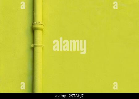 Texture de mur jaune et gouttière jaune de descente d'une maison. Photo appropriée pour l'arrière-plan ou la toile de fond de conception. Espace de copie pour la conception graphique. Banque D'Images