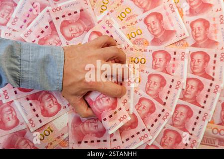 Main tenant US cent billets de yuan sur gris. Argent en yuan chinois. homme riche Banque D'Images