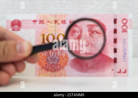 facture de 100 dollars et loupe blanche. les mains de l'homme tiennent des dollars et une loupe. Vérification de l'authenticité du banknot américain Banque D'Images