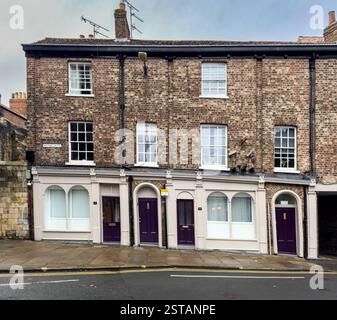 Rangée de maisons mitoyennes à Monkgate, toutes dotées de portes violettes distinctives. York. ROYAUME-UNI Banque D'Images