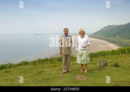 Prince Charles et Camilla, Duchesse de Cornouailles photographiés sur le chemin de falaise qui vous emmène au site de beauté Worms Head sur la péninsule de Gower près de Swansea en 2006. Le promontoire en arrière-plan est Burry Holmes avec la plage Rhossili balayant en dessous d'eux. Ils ont visité la petite communauté de Rhossili pour aider à célébrer le fait que la péninsule de Gower célèbre 50 ans depuis qu'elle a été déclarée zone d'une beauté naturelle exceptionnelle. Banque D'Images