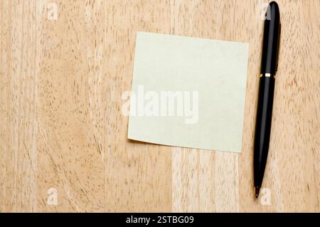 Bloc-notes stylo et post-it sur fond bois Banque D'Images