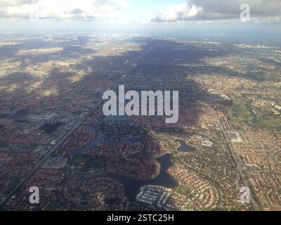 Vue aérienne d'une grande ville, Miami. Rivière sinueuse, gratte-ciel, espaces verts luxuriants. L'étalement urbain rencontre la nature. Veines et artères de la ville. Banque D'Images