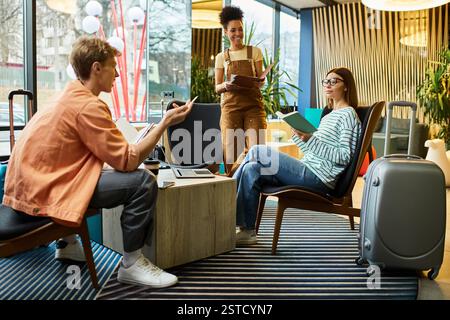 Trois collègues participent à des discussions et à la planification dans un hall d'hôtel élégant le matin. Banque D'Images