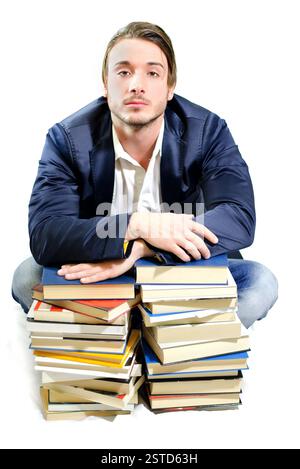 Étudiant fatigué d'étudier sur des piles de livres Banque D'Images