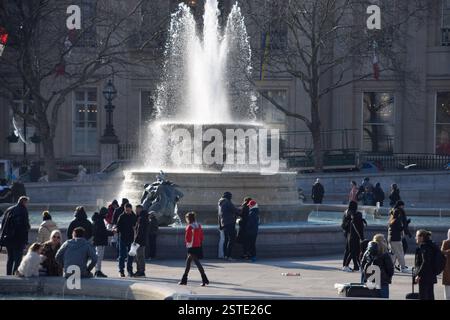 Londres, Angleterre, Royaume-Uni. 18 février 2025. Les gens apprécient le soleil à côté des fontaines de Trafalgar Square car les températures sont censées augmenter pendant la semaine. (Crédit image : © Vuk Valcic/ZUMA Press Wire) USAGE ÉDITORIAL SEULEMENT! Non destiné à UN USAGE commercial ! Banque D'Images