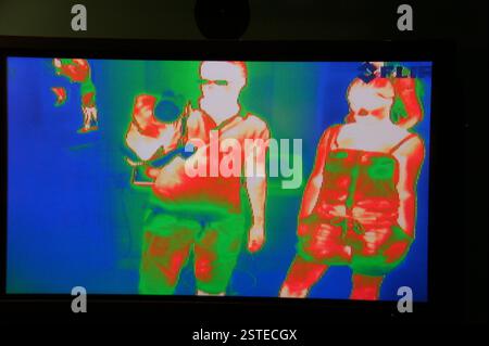Image thermique de deux personnes debout à Boston. Homme en short et débardeur, femme en short et débardeur. Des couleurs plus chaudes indiquent un températu corporel plus élevé Banque D'Images