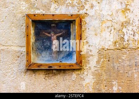 Peinture religieuse encadrée en bois sur Un mur rustique texturé Banque D'Images